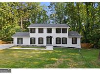 Two story house with white brick and black shutters, freshly landscaped lawn at 388 Fieldstone Sw Ct, Lilburn, GA 30047