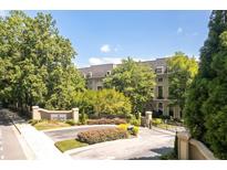 Luxury condo building with gated entrance, lush landscaping, and meticulously maintained grounds at 2865 Lenox Ne Rd # 208, Atlanta, GA 30324