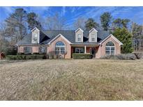 Brick house with dormer windows, landscaping, and a large yard at 90 Ashford Dr, Oxford, GA 30054