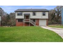 Two-story house with brick and siding, a grassy yard, and a driveway at 2729 Oxford Dr, Decatur, GA 30034