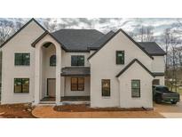 Newly constructed two-story home featuring white brick, black trim, and an arched entryway at 2977 N Bogan Ne Rd, Buford, GA 30519