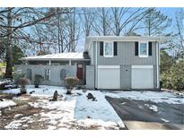 Gray two-story house with a two-car garage and a snow-covered front yard at 4509 Central Dr, Stone Mountain, GA 30083
