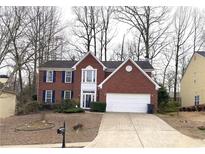 Traditional two-story brick home with a well-manicured lawn and attached two-car garage at 1999 Riverlanding Cir, Lawrenceville, GA 30046