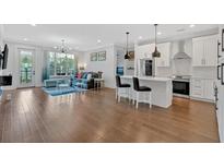 Bright and airy living room featuring hardwood floors, comfortable seating, and a modern ceiling fan at 6890 Peachtree Dunwoody Rd # 303, Atlanta, GA 30328