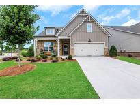 Brick front exterior of charming house with two-car garage and landscaped lawn at 2955 Steinbeck St, Cumming, GA 30041