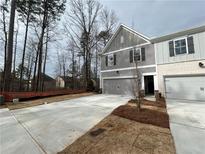 Charming two-story townhome with gray siding, brick accents, and a spacious driveway at 401 Carrera Ln, Acworth, GA 30102