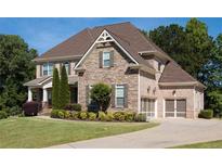 Stone and brick two-story house with three-car garage and landscaped lawn at 6529 Terraglen Way, Locust Grove, GA 30248