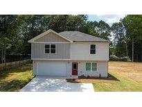 Two-story house with gray and beige siding, a red door, and a two-car garage at 1331 E Atlanta E Rd, Stockbridge, GA 30281