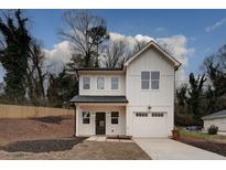 Two-story farmhouse with white siding, black roof, and attached garage at 2127 Nichols Ln, Decatur, GA 30032