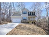 Two-story house with light beige siding, stone accents, and a two-car garage at 509 Ajo Way, Dallas, GA 30157