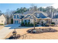 Two-story home with gray siding, brick accents, and a three-car garage at 4960 Shade Creek Xing, Cumming, GA 30028