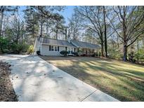 Ranch style home with a large yard and driveway at 7270 Oswego Trl, Riverdale, GA 30296