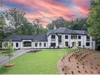 Stunning two-story home with a white brick facade and a landscaped yard at 5271 Lake Forrest Dr, Atlanta, GA 30342