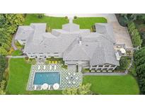 Stunning aerial view of home featuring in-ground pool with an outdoor seating and lush green landscaping at 3612 Castlegate Nw Dr, Atlanta, GA 30327