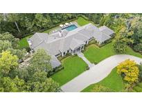 Stunning aerial view of a home surrounded by lush greenery and a luxurious pool with umbrellas at 3612 Castlegate Nw Dr, Atlanta, GA 30327