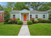 Charming one-story home with a bright orange front door, lush lawn, and manicured landscaping at 67 Holly Nw Rd, Atlanta, GA 30314