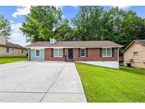 Charming brick home with a spacious front yard and long driveway at 2382 Old Rex Morrow Rd, Ellenwood, GA 30294