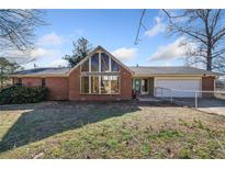 Brick ranch house with large window, attached garage, and fenced yard at 4386 Bluebird Ln, Lithia Springs, GA 30122