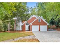 Brick house with two-car garage and landscaped lawn at 4851 Ridgewood Creek Nw Dr, Acworth, GA 30102