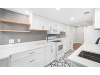 Modern white kitchen with hexagon floor tile, quartz countertops, and gold accents at 18 Ivy Ne Rdg, Atlanta, GA 30342