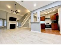 Spacious living room featuring a fireplace, ceiling fan, and an open view to the kitchen at 4234 Stillwater Dr, Duluth, GA 30096