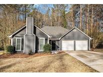 Gray house with white garage doors and landscaping at 6602 Crossing Creek Pt, Austell, GA 30168