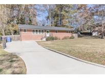 Brick ranch home with a large yard and a long driveway at 2575 Baker Nw Rd, Atlanta, GA 30318