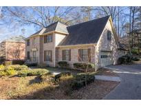 Charming two-story brick home with an attached garage, surrounded by lush landscaping and mature trees at 4116 River Cliff Chase Se, Marietta, GA 30067