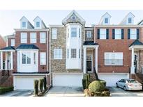 Brick front of charming townhome with 2-car garage and landscaped yard at 1292 Creekside Se Ter, Smyrna, GA 30082