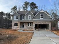 New two-story home with gray siding, brick accents, and a two-car garage on a spacious lot at 1020 Cottonwood Ln, Loganville, GA 30052