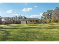 Charming one-story home featuring a cozy front porch and a spacious green lawn at 3245 Pope Rd, Douglasville, GA 30135