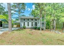 Charming two-story home with a well-maintained front yard and inviting curb appeal surrounded by mature trees at 6360 Ashdale Dr, Atlanta, GA 30349