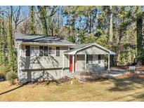 Ranch style home with gray exterior, red door, and landscaped yard at 2456 Colorado Sw Trl, Atlanta, GA 30331