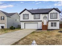 Two-story house with white and black exterior, attached garage, and a wooden staircase at 3094 Jonesboro St, Ellenwood, GA 30294