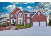 Brick home with two-car garage and landscaped yard at 5615 Forkwood Nw Dr, Acworth, GA 30101