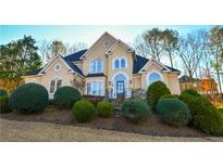 Two-story house with stucco exterior, landscaping, and a welcoming front entrance at 605 Rose Creek Cir, Duluth, GA 30097
