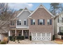 Brick and gray siding two-story home with a three-car garage at 1240 Roswell Manor Cir, Roswell, GA 30076