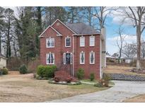 Brick two-story house with a landscaped yard and driveway at 1031 Bettina Sw Ct, Mableton, GA 30126