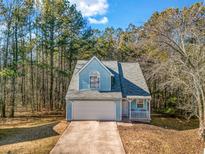 Cute light blue house with a gray roof, white garage door, and small porch at 5392 Brickleberry Way, Douglasville, GA 30134