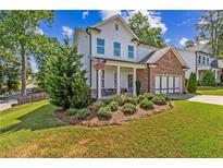 Two-story brick and white home with landscaped yard and attached garage at 253 N Gwinnett St, Buford, GA 30518