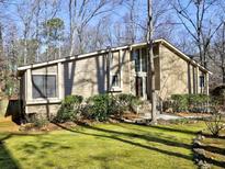 Tan house with wood-like siding, surrounded by trees and landscaping at 1550 Oak Creek Dr, Marietta, GA 30066