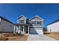 Two-story home with gray siding, white trim, covered porch, and attached garage at 2422 Brown Dove Way Lot 70, Grayson, GA 30017