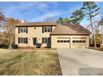 Two-story house with attached garage and landscaped lawn at 978 Gwens Sw Trl, Lilburn, GA 30047