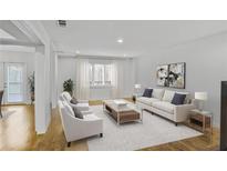Bright living room with wood floors, white sofa and chairs, and lots of natural light at 3036 Vinings Ferry Se Dr, Atlanta, GA 30339