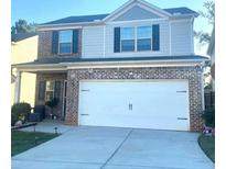 Two-story brick home with a large driveway and landscaped lawn at 10954 Wheeler Trce, Hampton, GA 30228