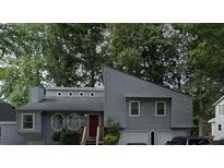 Gray two-story house with attached garage and mature trees at 1358 Millstream Trl, Lawrenceville, GA 30044