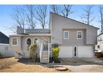 Gray two-story house with attached two-car garage and landscaping at 1358 Millstream Trl, Lawrenceville, GA 30044