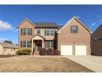 Brick two-story house with a two-car garage and landscaping at 3849 Sweet Iris Cir, Loganville, GA 30052