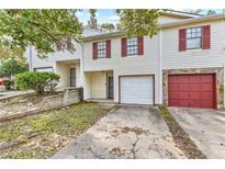 Charming townhome with red shutters, a one-car garage, and a well-kept lawn at 3008 Pine Tree Trl # 16D, South Fulton, GA 30349