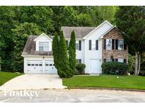 Two-story home with a two car garage, a manicured lawn and decorative evergreen shrubs at 2295 Creekview Trl, Decatur, GA 30035